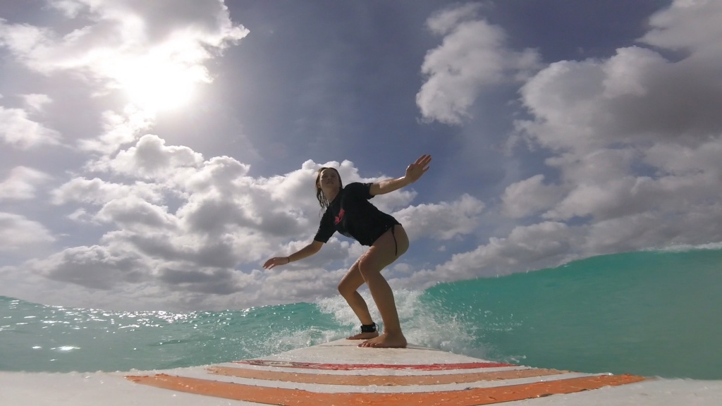 Woman surfing with Ride the Tide GoPro front Mounts
