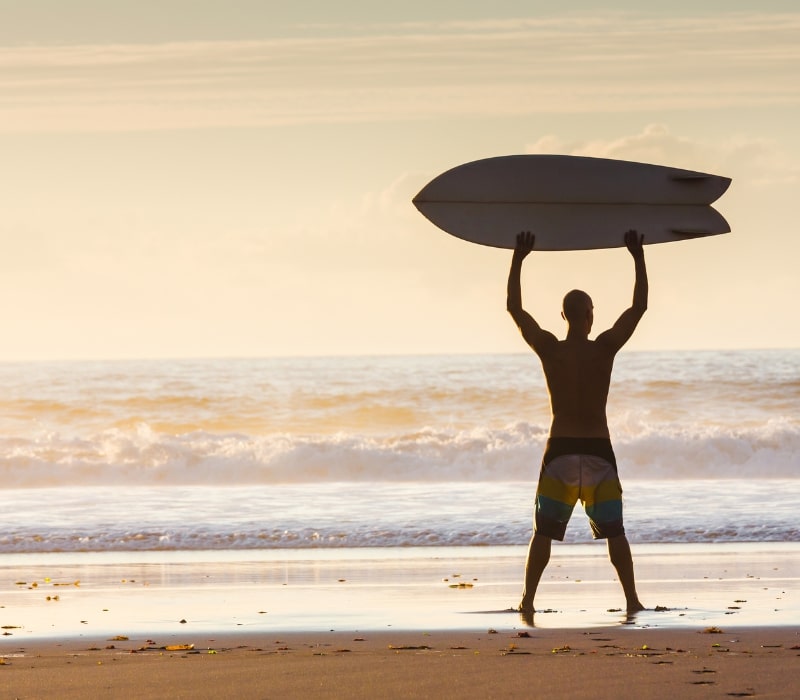 man holding surfboard in barbados